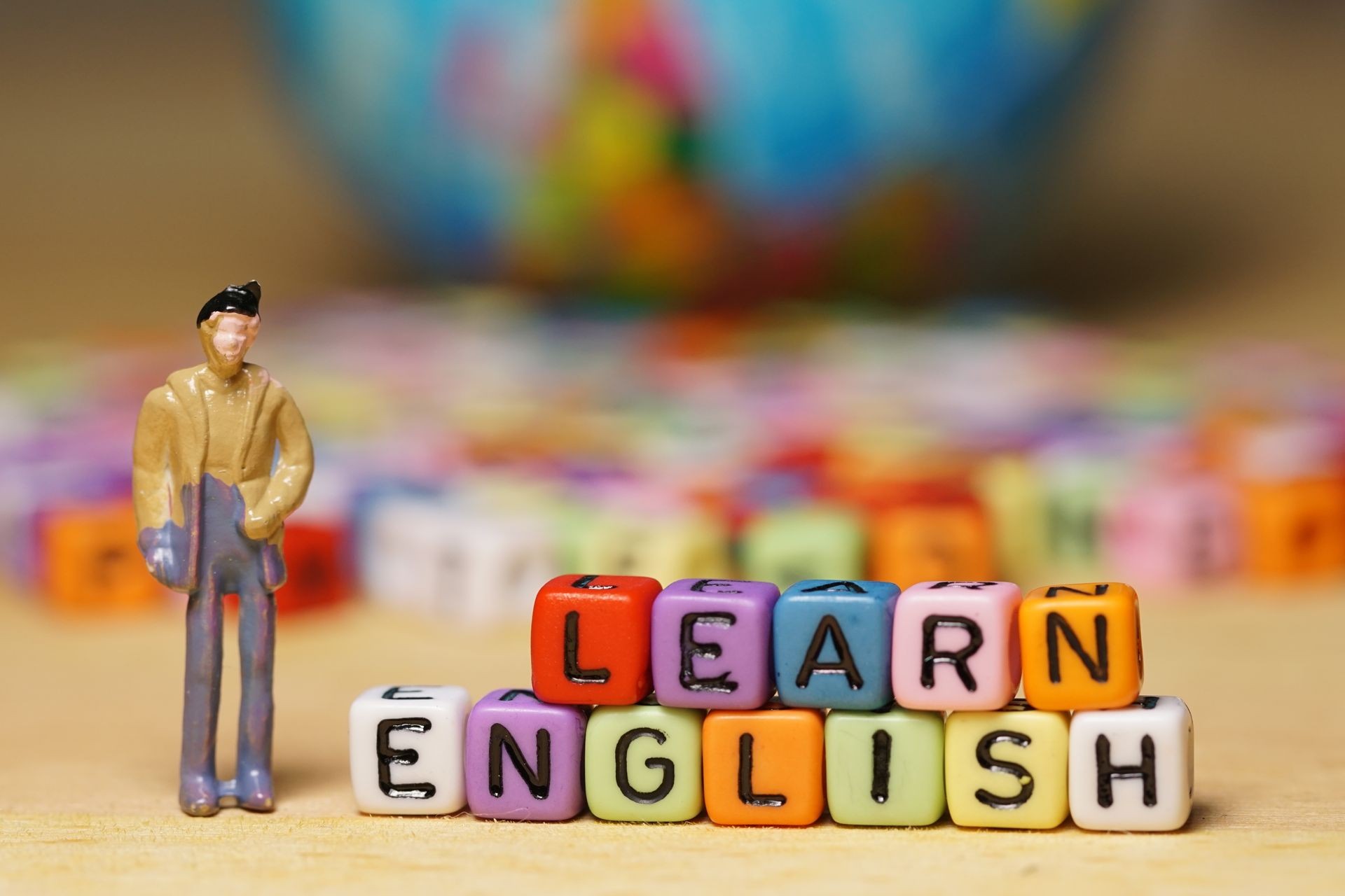 LEARN ENGLISH words made of colorful beads and miniature man act as a teacher. Educational concept